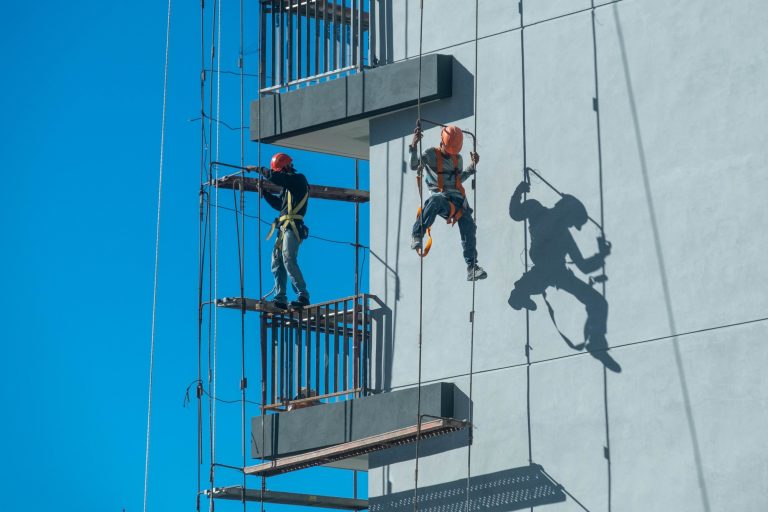 couple-workers-fixing-climbing-scaffolding-while-following-all-safety-measures-resize
